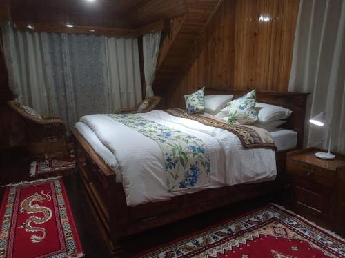 a bedroom with a large bed with a wooden headboard at Ganga Homestay in Darjeeling
