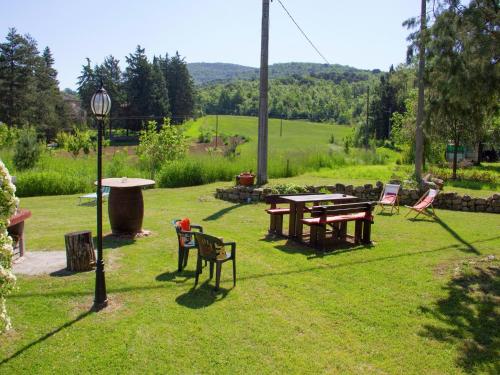 a group of tables and chairs in a yard at Modern Holiday Home in Pietrafitta Umbria with Garden in Pietrafitta