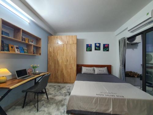 a bedroom with a bed and a desk with a laptop at The Chilling'N Homestay Ha Noi 89 in Hanoi