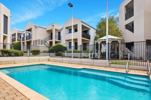 a swimming pool in front of some apartment buildings at Ground Garden-Two King Beds&One Queen Bed in Perth