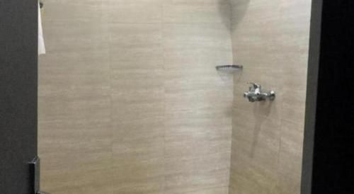 a shower in a bathroom with a metal shower head at Mega Permata Hotel in Padangsidimpuan
