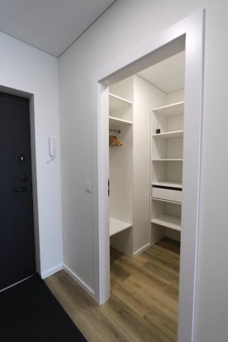 a walk in closet with white walls and a mirror at Flat for 2 or 1 with Free Parking and Fast Wi-Fi in Vilnius
