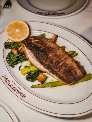 a plate of food with a piece of fish and vegetables at Grand Hyatt Erawan Bangkok in Bangkok