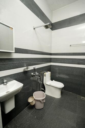 a bathroom with a toilet and a sink at Royal Turn Modern Villa in Alleppey