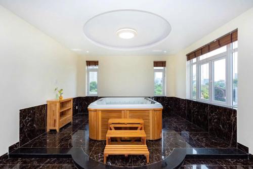 a jacuzzi tub in a room with windows at BIỆT THỰ NGHĨ DƯỠNG CAO CẤP THUỲ VÂN BÃI SAU VŨNG TÀU-Mt VƯƠNG VILLA in Vung Tau