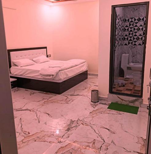 a bedroom with a bed and a marble floor at Hotel New Residency Ayodhya in Ayodhya