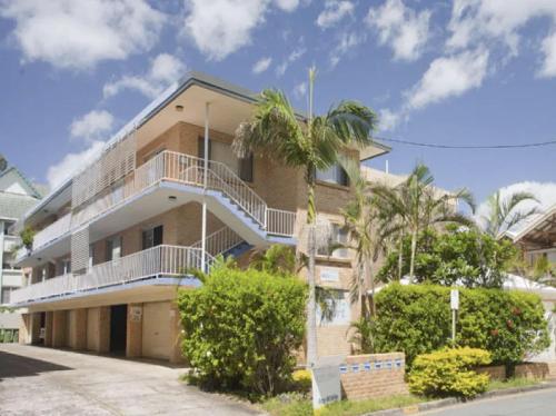 an apartment building with a balcony and palm trees at Surf Shack in Iconic Rainbow Bay - Coolangatta QLD (pet friendly) in Gold Coast