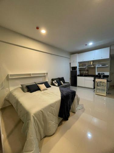 a bedroom with a large bed and a kitchen at Monoambiente p3 personsas a pasos de Av Sta Teresa Asuncion, con balcon y Gran vista in Fernando de la Mora