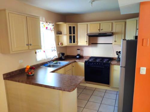 a kitchen with white cabinets and a black refrigerator at Casa céntrica--zona vado del rio in Hermosillo