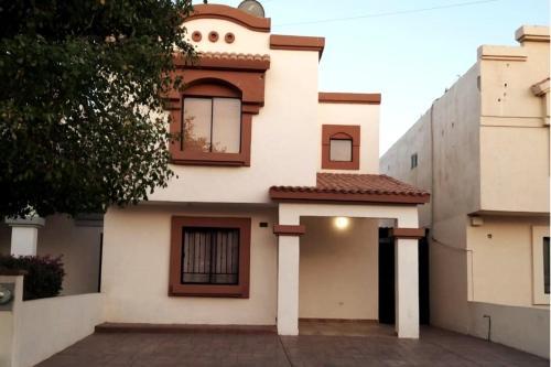 a white house with brown trim and windows at Casa céntrica--zona vado del rio in Hermosillo