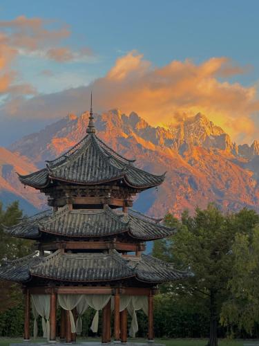 a pagoda with a mountain in the background at Banyan Tree Lijiang in Lijiang