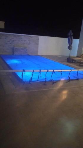 a swimming pool is lit up at night at Villa Dalissa avec piscine chauffée in Awlād ‘Umar