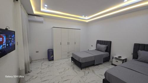 a bedroom with two beds and a tv in it at Villa Dalissa avec piscine chauffée in Awlād ‘Umar