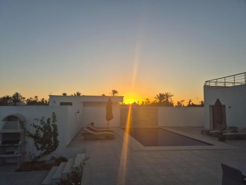 a sunset on the roof of a house at Villa Dalissa avec piscine chauffée in Awlād ‘Umar