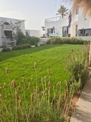 a lawn in front of a house at Villa Dalissa avec piscine chauffée in Awlād ‘Umar