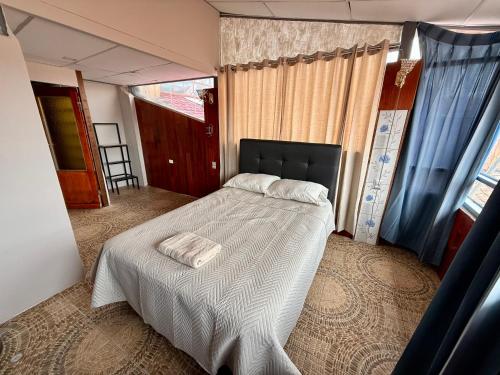 una camera da letto con un letto con un piumone bianco di Rustic House in the Heart of Cusco a Cuzco