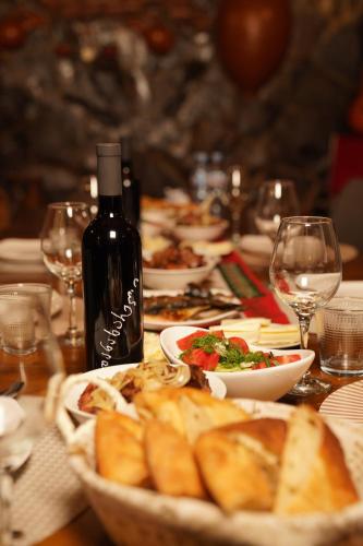 a table with plates of food and a bottle of wine at Hotel Hobbiton near Vardzia Caves in T'mogvi