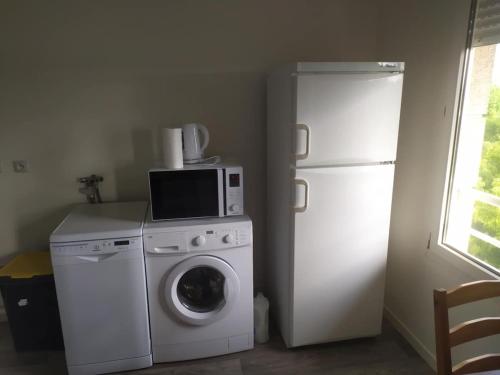 a kitchen with a washing machine and a refrigerator at T1 TOURS NORD 38m2 proche autoroute in Tours