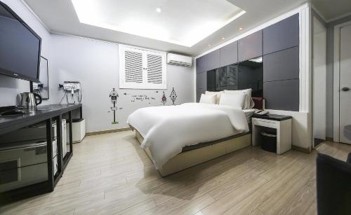 a bedroom with a large bed and a flat screen tv at Zenith Hotel in Guri