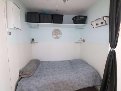 - une petite chambre avec un lit dans une caravane dans l'établissement Studio Cosy avec Piscine et Parking au Grau-du-Roi - FR-1-307-287, au Grau-du-Roi