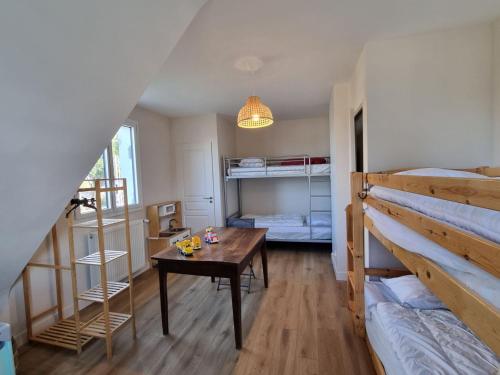 une chambre avec deux lits superposés et une table dans l'établissement Maison rénovée 2023 proche plage, Arzon, 10 pers, jardin, wifi - FR-1-775-30, à Arzon