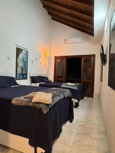 a bedroom with two beds with blue sheets at suite ao som do mar - tombo guaruja in Guarujá