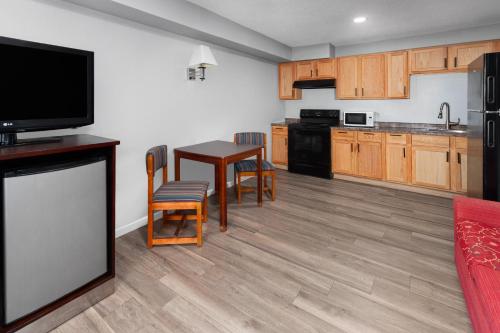 a kitchen with a table and chairs and a television at Super 8 by Wyndham Sun Prairie/Madison E in Sun Prairie