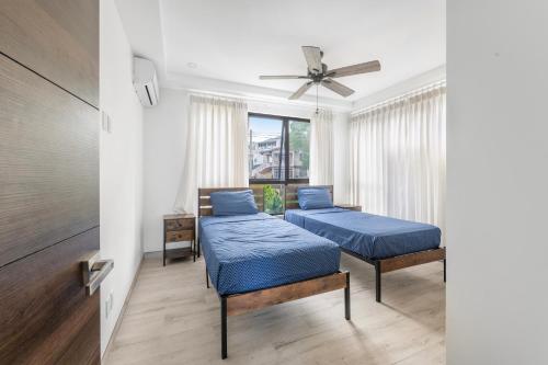 une chambre avec deux lits et un ventilateur de plafond dans l'établissement the views by DanTopia villa, à Saint James