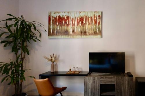 a living room with a desk with a television and a painting at Oaktown Roost in Oakland