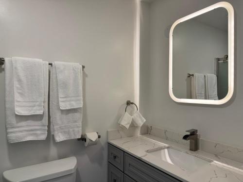 a white bathroom with a sink and a mirror at Oaktown Roost in Oakland