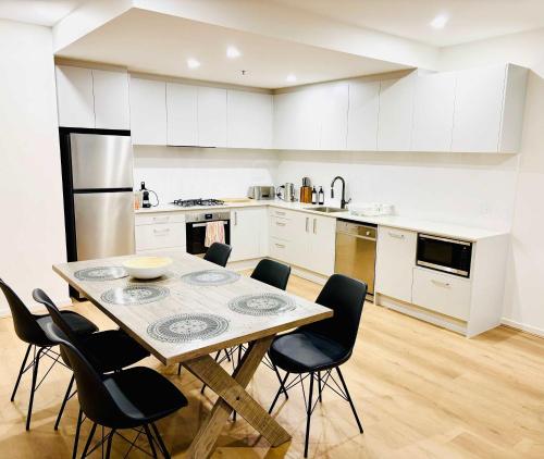 a kitchen with a table and chairs in it at 2-Bedroom Apartment in Melbourne City with carpark in Melbourne
