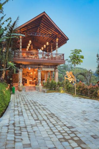 a large wooden building with a balcony on top at Harsa Sanctuary by GenuineHost in Ubud