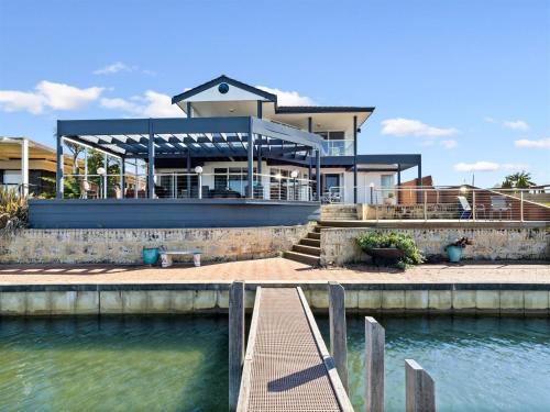 une maison avec un quai en face d'une masse d'eau dans l'établissement Private Jetty -family & Pet Friendly, à Mandurah