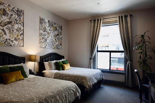 a hotel room with two beds and a window at Oaktown Roost in Oakland