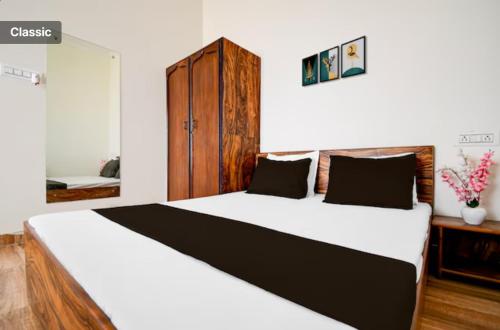 a bedroom with a large bed with a wooden cabinet at The Vasudha Estate in Lucknow