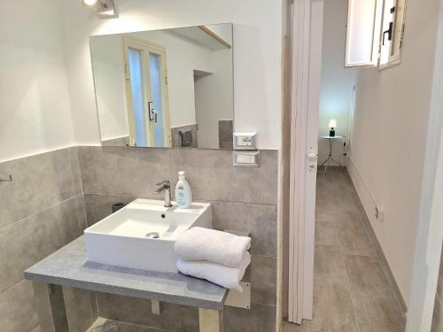 a bathroom with a white sink and a mirror at Nata Sicula 3 in Siracusa