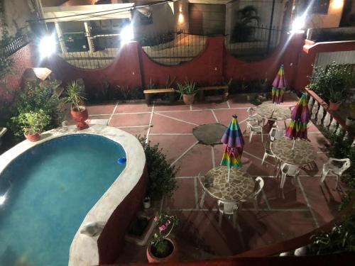 eine Außenterrasse mit Swimmingpool sowie Tischen und Sonnenschirmen in der Unterkunft Hotel Las Flores in Acapulco