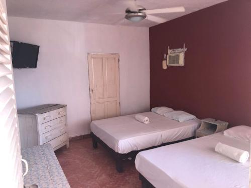 1 Schlafzimmer mit 2 Betten, einem Schrank und einem TV in der Unterkunft Hotel Las Flores in Acapulco