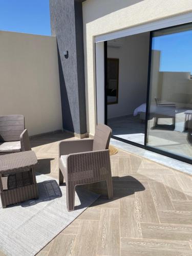 a living room with a patio with chairs and a couch at La Villa Margautin in Arkou