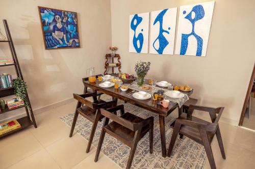 a dining room with a wooden table and chairs at The Lotus Loft in New Delhi