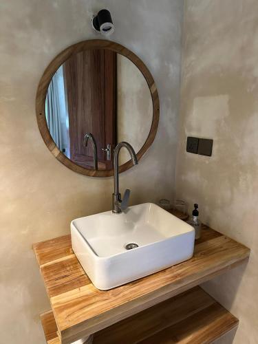 a bathroom with a white sink and a mirror at Maisha Nungwi - Boutique Hotel in Nungwi