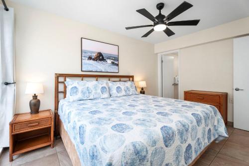 une chambre avec un lit et un ventilateur de plafond dans l'établissement Sea Village 4213, à Kailua-Kona