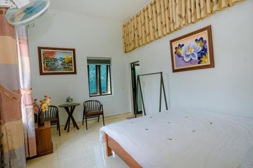 a bedroom with a bed and a table and chairs at Tam Coc Moon Homestay in Vũ Lâm