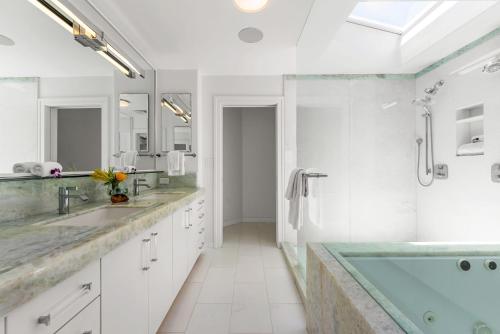 a bathroom with two sinks and a bath tub at Lanikai Sunrise in Kailua
