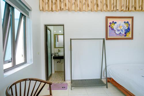 a bedroom with a mirror and a bed and a chair at Tam Coc Moon Homestay in Vũ Lâm