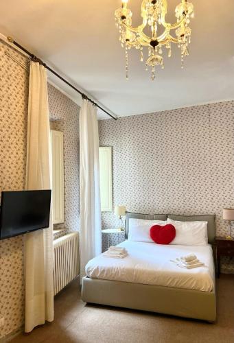 a bedroom with a bed with a red heart pillow at La casa di vella via in Lucca