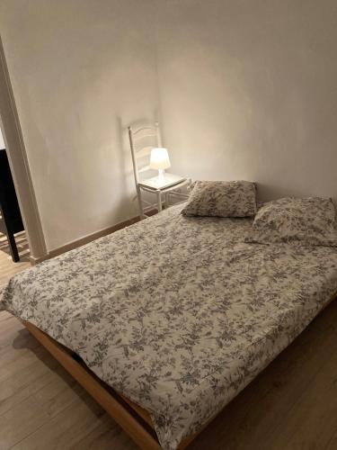 - une chambre avec un lit, une chaise et une lampe dans l'établissement appartement 4 personnes sete centre, à Sète