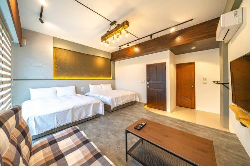 a hotel room with two beds and a couch at 寵物友善-無門禁24小時進出-烏石驛站民宿-免費停車 in Toucheng