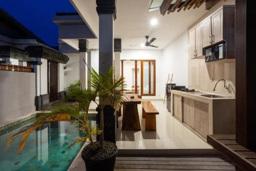 a kitchen with a swimming pool in a house at Om Villas Kedungu in Tanah Lot