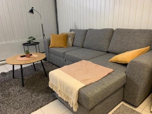 a living room with a gray couch and a table at Tilava 2mh rivitalo, WiFi in Oulu